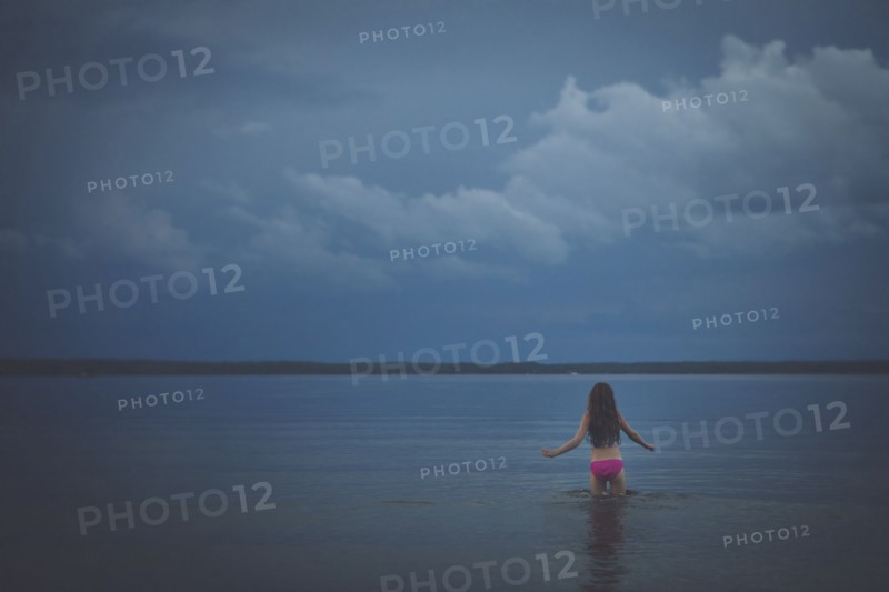 Caucasian girl wading in remote lake