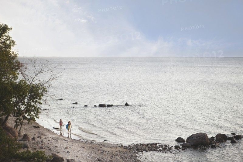 Caucasian girls standing on remote beach