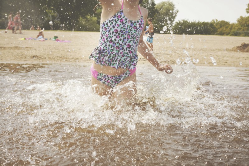 Caucasian girl splashing in waves on beach