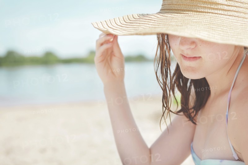 Caucasian teenage girl wearing sun hat on beach