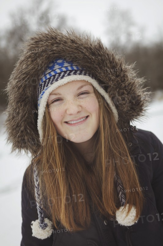 Caucasian teenage girl wearing fur coat and hat in snow