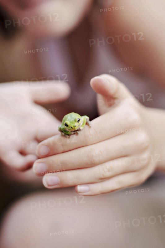 Caucasian girl playing with frog
