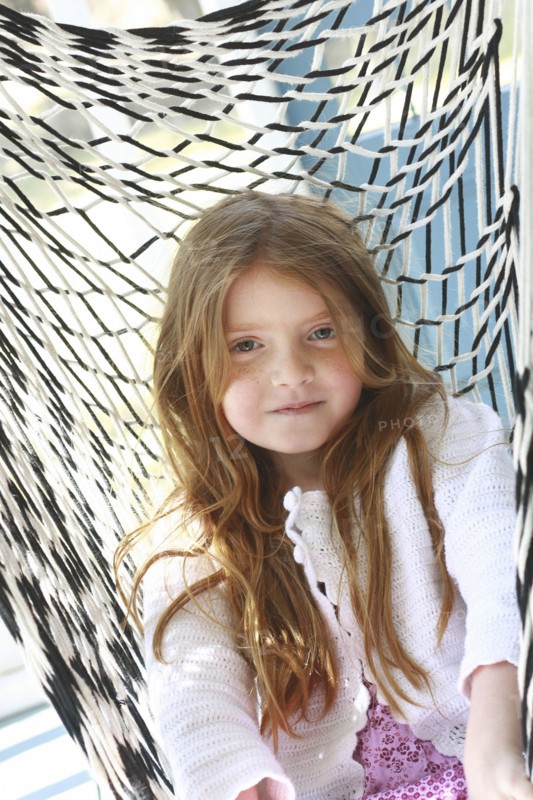 Caucasian girl sitting in hammock