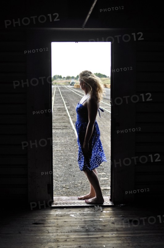 Woman standing in doorway of train in train yard