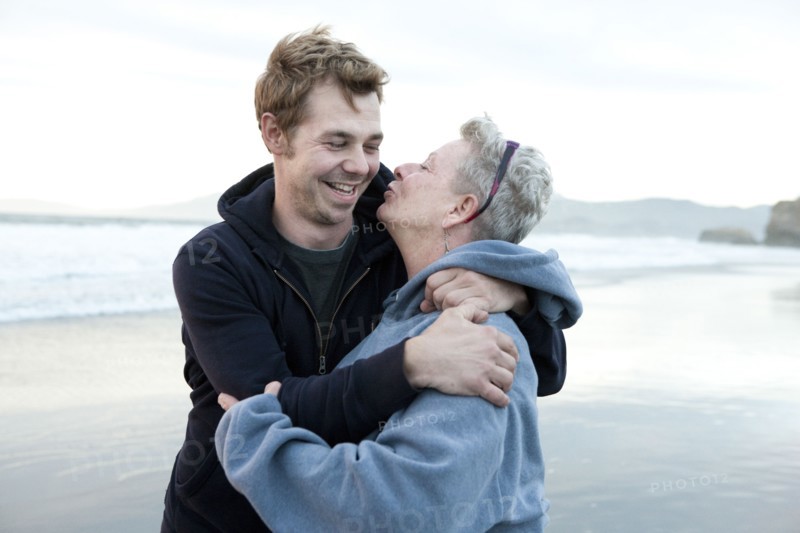 Caucasian mother and son hugging on beach