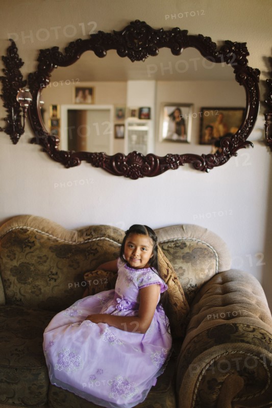 Hispanic girl sitting on living room sofa