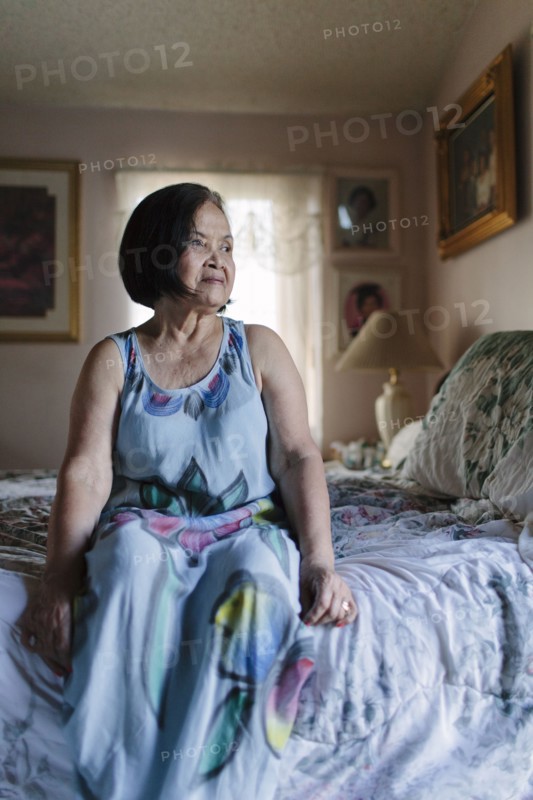 Smiling older woman sitting on bed