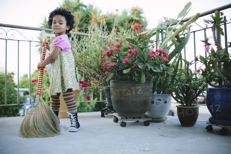 Girl sweeping patio with broom