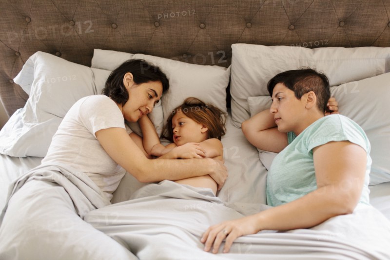 Caucasian family laying in bed