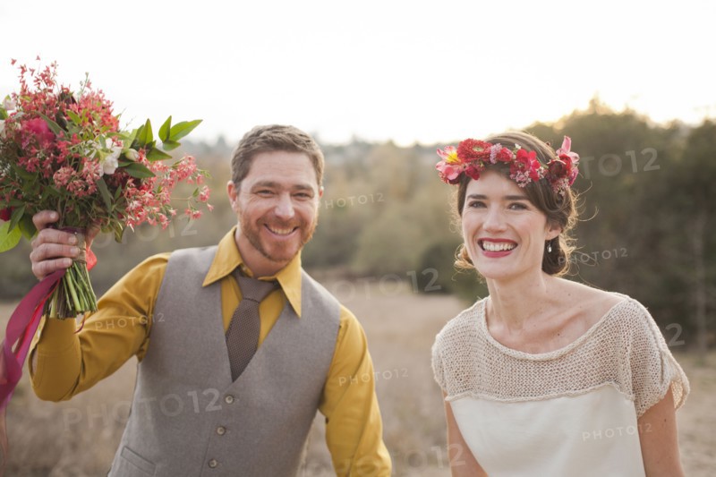 Bride and groom smiling in rural field