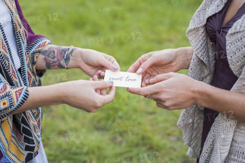 Close up of friends holding sweet love card