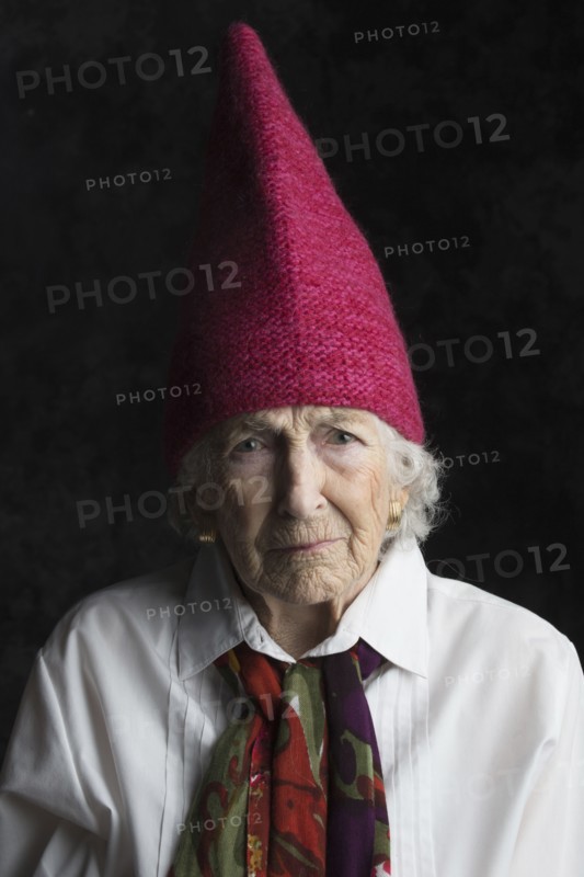 Close up of older woman wearing dunce cap