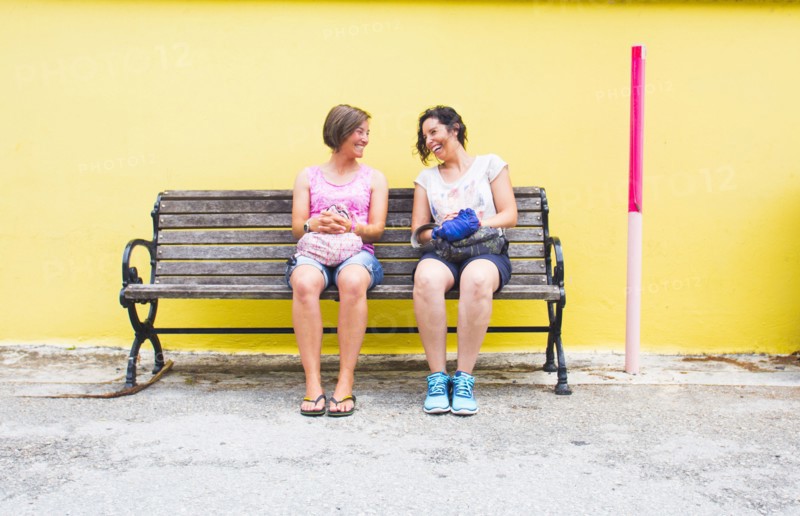 Caucasian women talking on bench