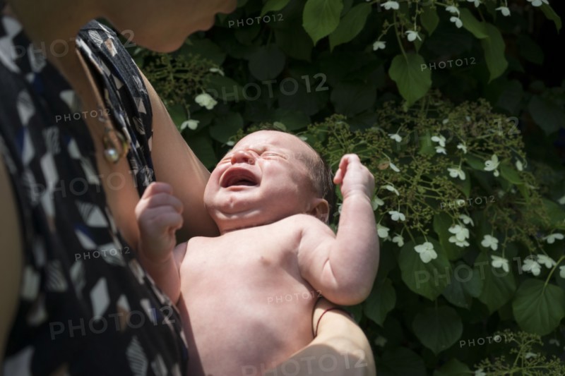 Mother holding crying baby in arms