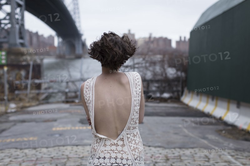Woman in low-back dress walking in industrial area