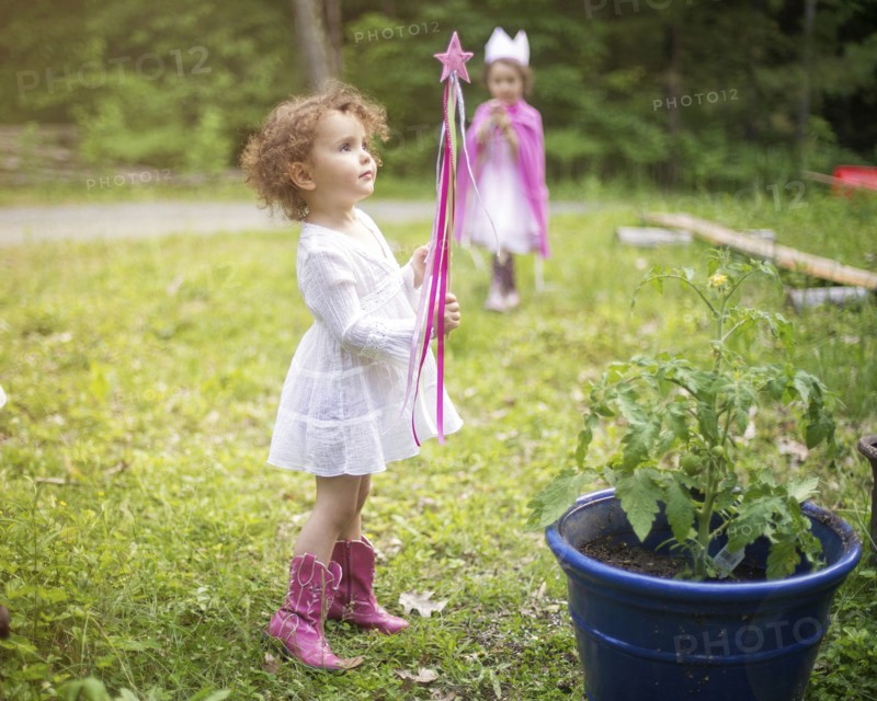 Girl playing with wand in backyard garden