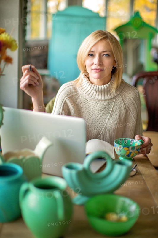 Caucasian entrepreneur using laptop in shop