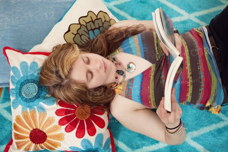 Caucasian woman reading book on floor