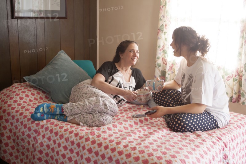 Caucasian mother and daughter playing cards in bedroom