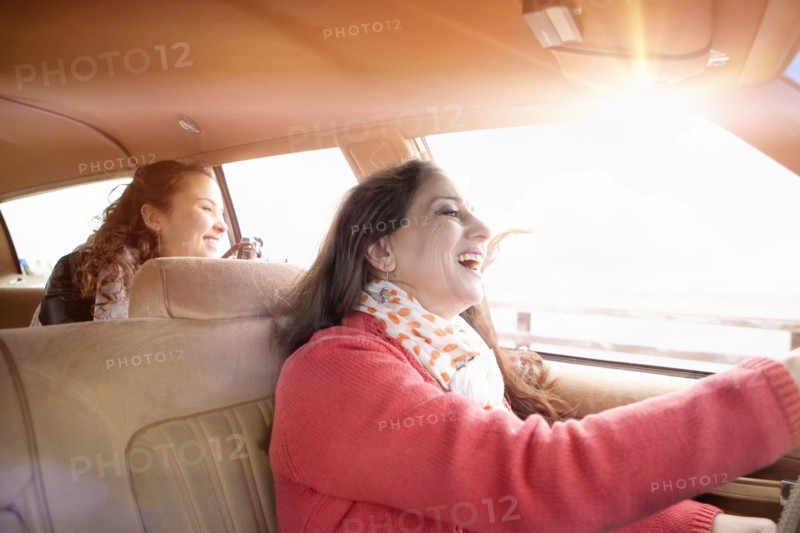 Caucasian mother and daughter driving in car