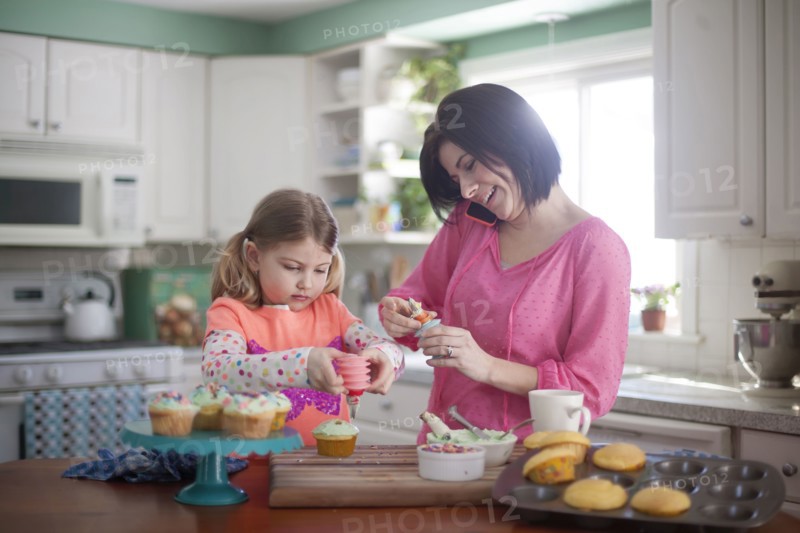 Caucasian mother and daughter baking in kitchen