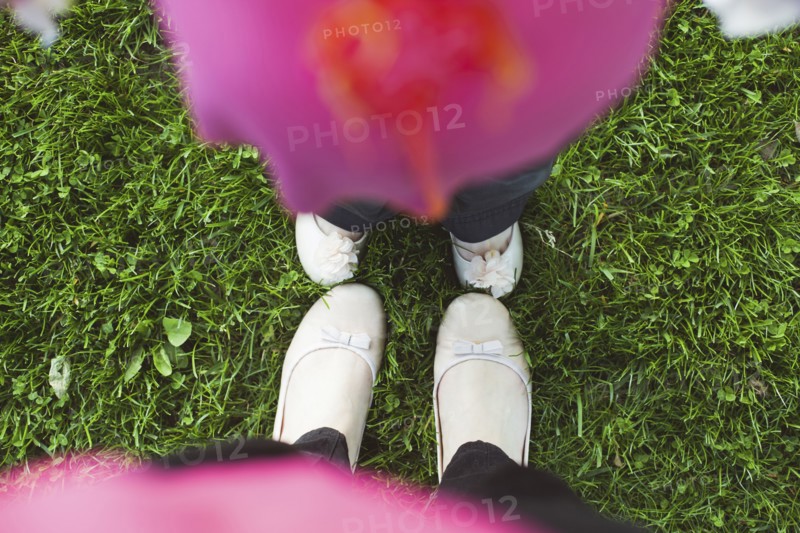 High angle view of feet of mother and daughter in grass