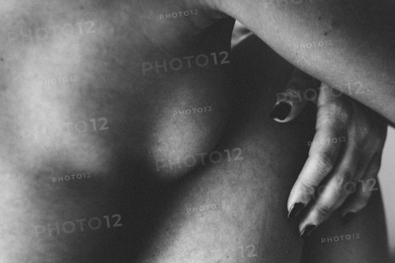 Close up of nude woman hugging her knees