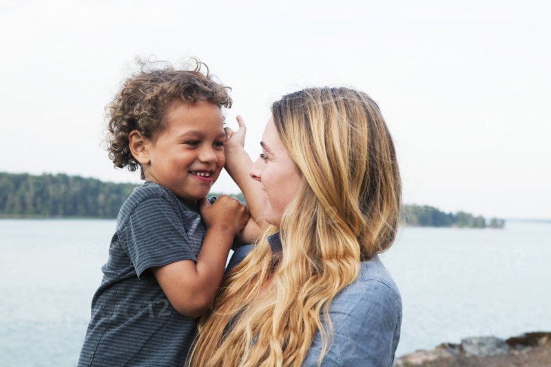 Mother holding son at rural lake