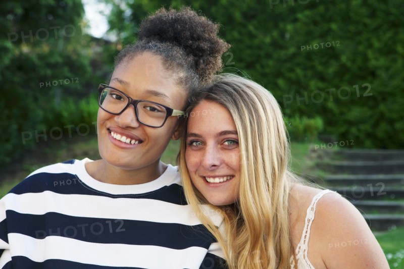 Teenage girls hugging in park