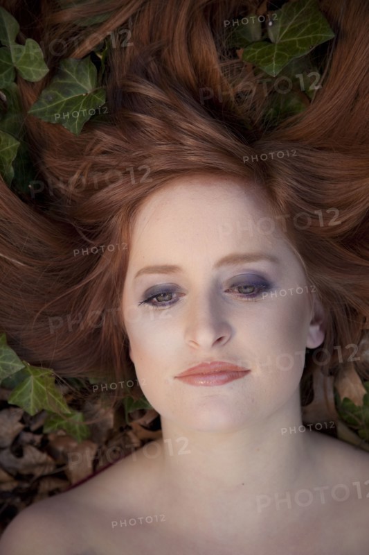 Close up of serious Caucasian woman laying in leaves