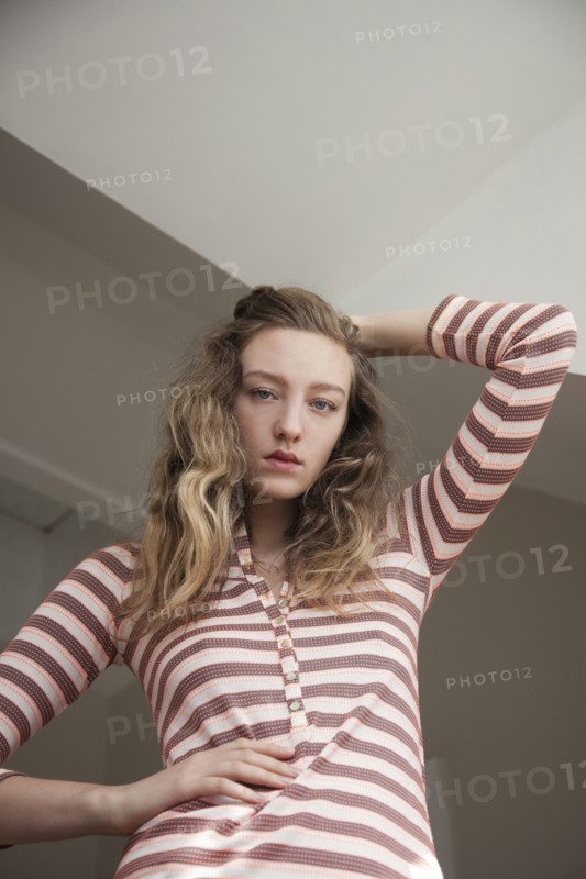 Low angle view of woman posing under gray sky