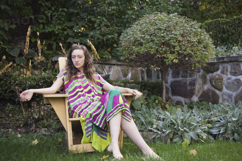 Woman sitting in lawn chair in backyard
