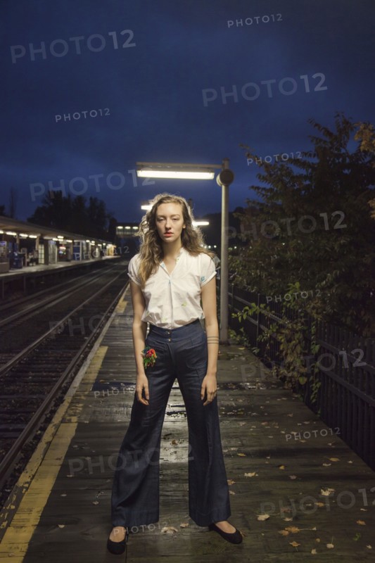 Woman waiting for train at train station at night