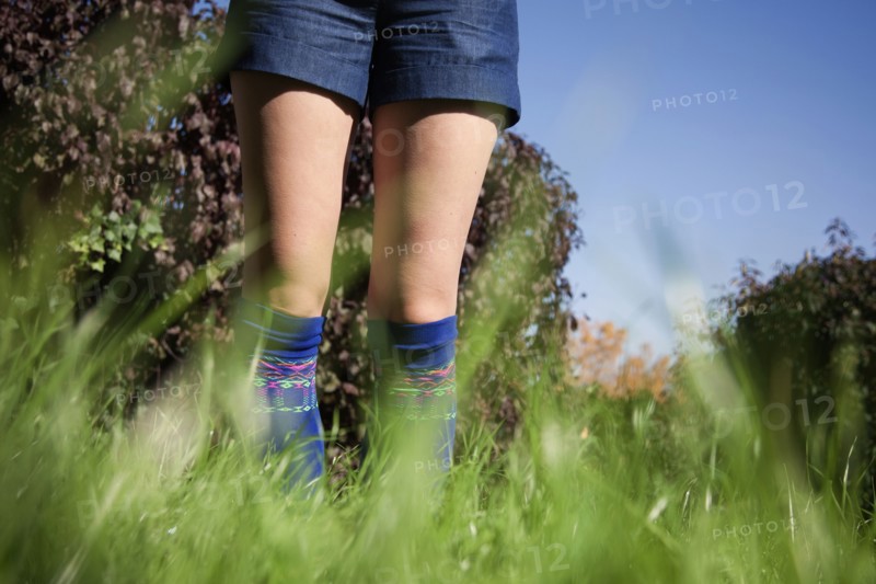 Woman wearing shorts and socks in tall grass