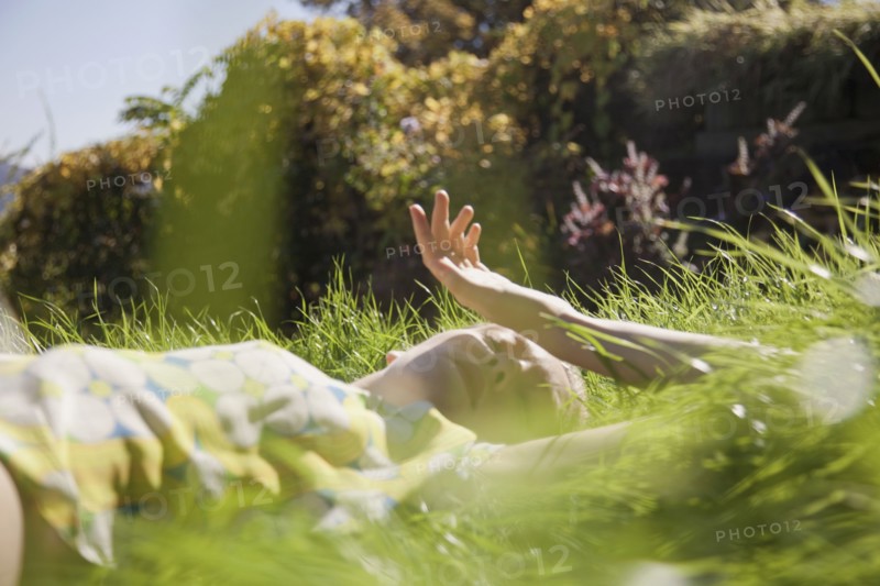 Woman laying in tall grass in park