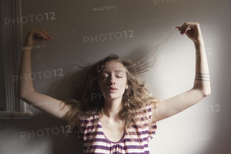 Woman playing with her hair in sunlight