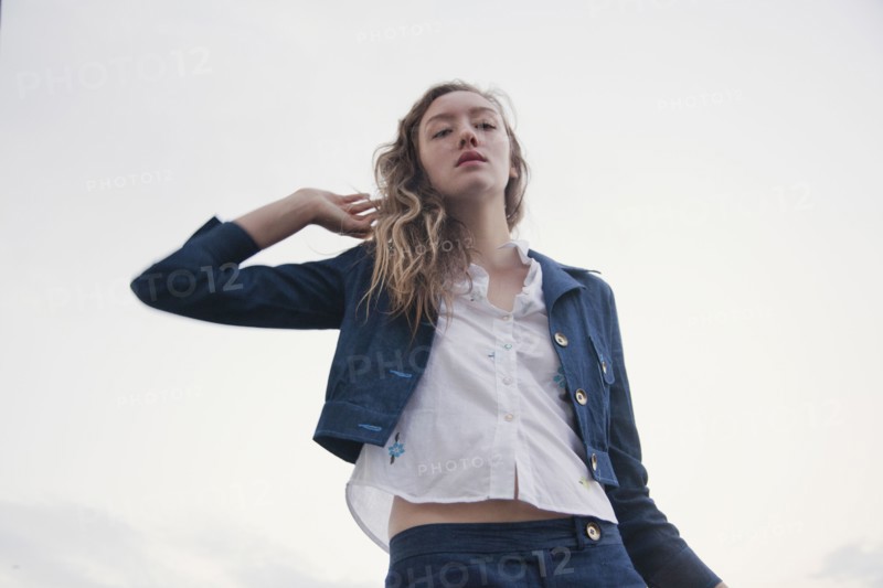 Woman wearing jacket under cloudy sky