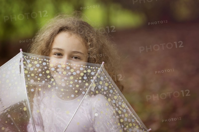 Caucasian girl playing with umbrella outdoors