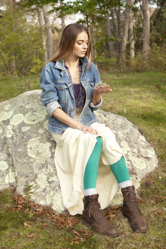 Woman examining plants in forest