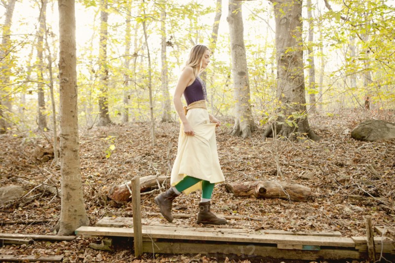 Woman walking on wooden walkway in forest