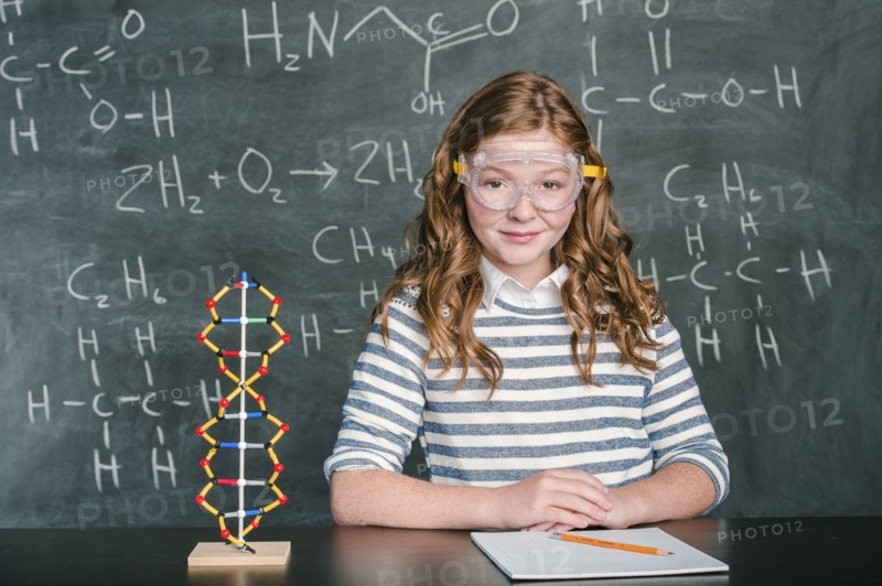 Caucasian student wearing safety goggles in science class