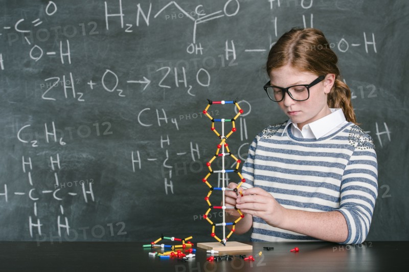 Caucasian student examining molecular model in science class
