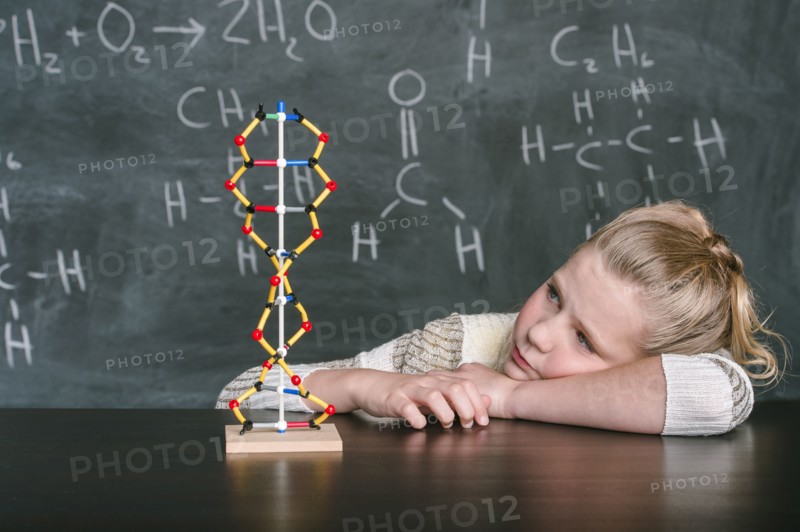 Caucasian student examining molecular model in science class
