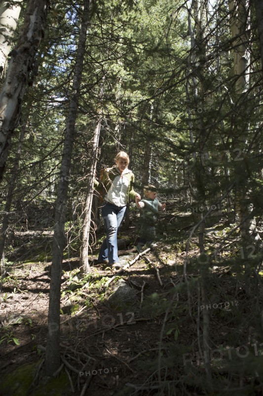 Woman walking on forested hillside