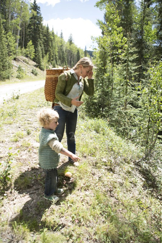 Mother and son exploring on forest hillside