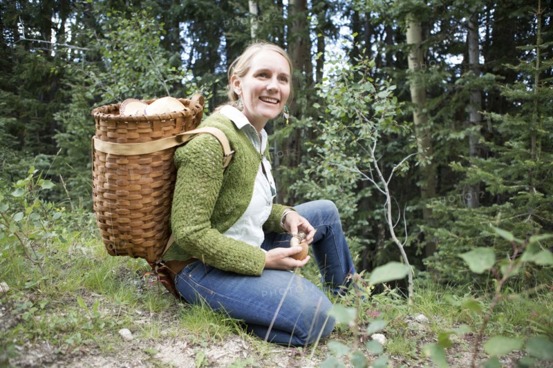 Woman foraging for mushrooms in forest