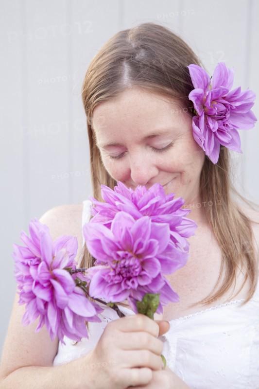 Mixed race woman smelling flowers