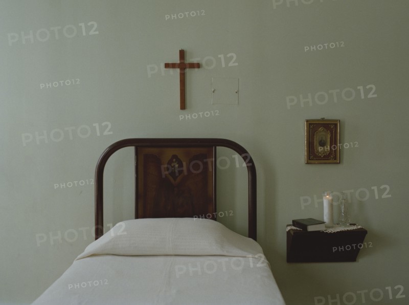 Crucifix over bed in simple bedroom