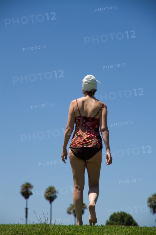 Caucasian woman wearing bathing suit in grass