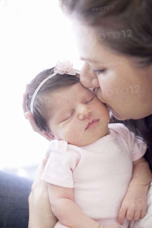 Caucasian mother kissing baby girl